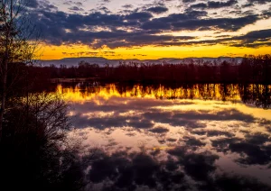 Wolkenspiegelung beim Sonnenaufgang am Urloffer Baggersee